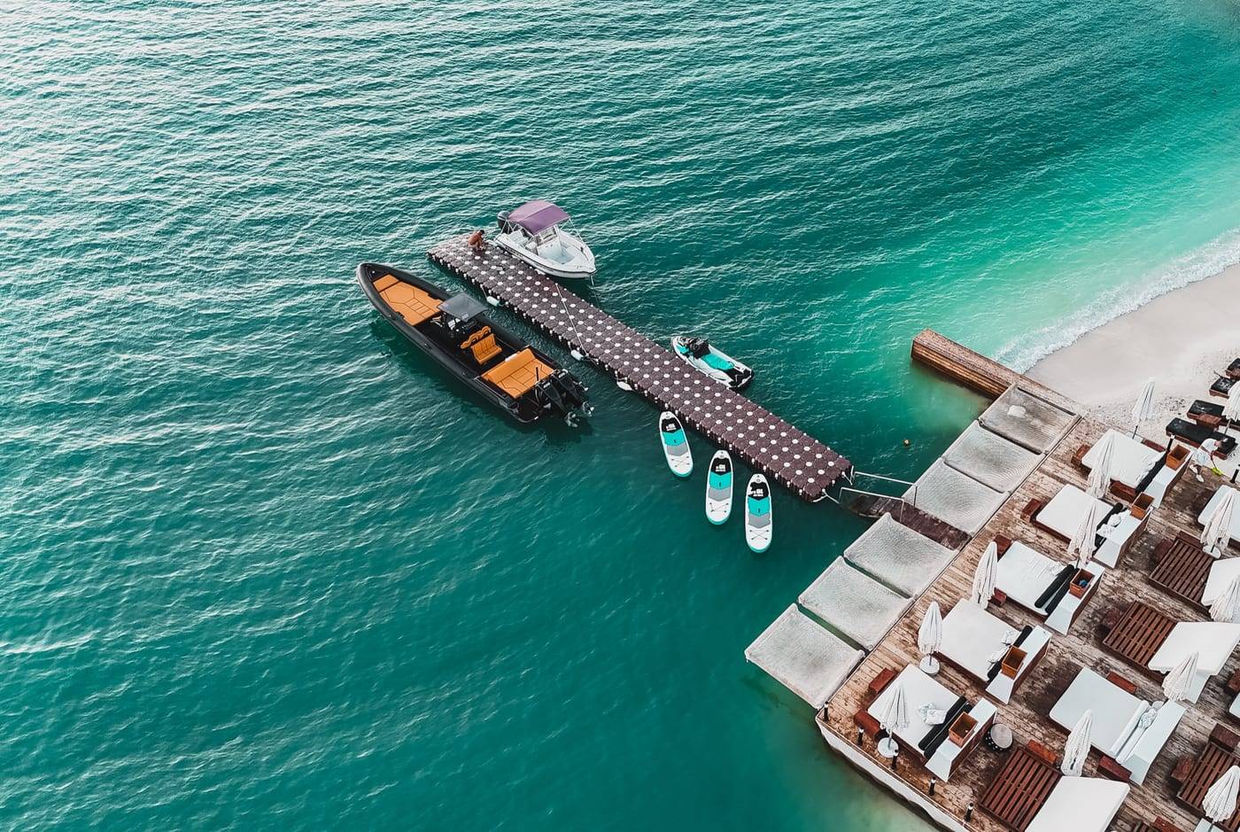 Principotes in Ksamil from the air: the jetty with boats and paddleboards beside the beach club