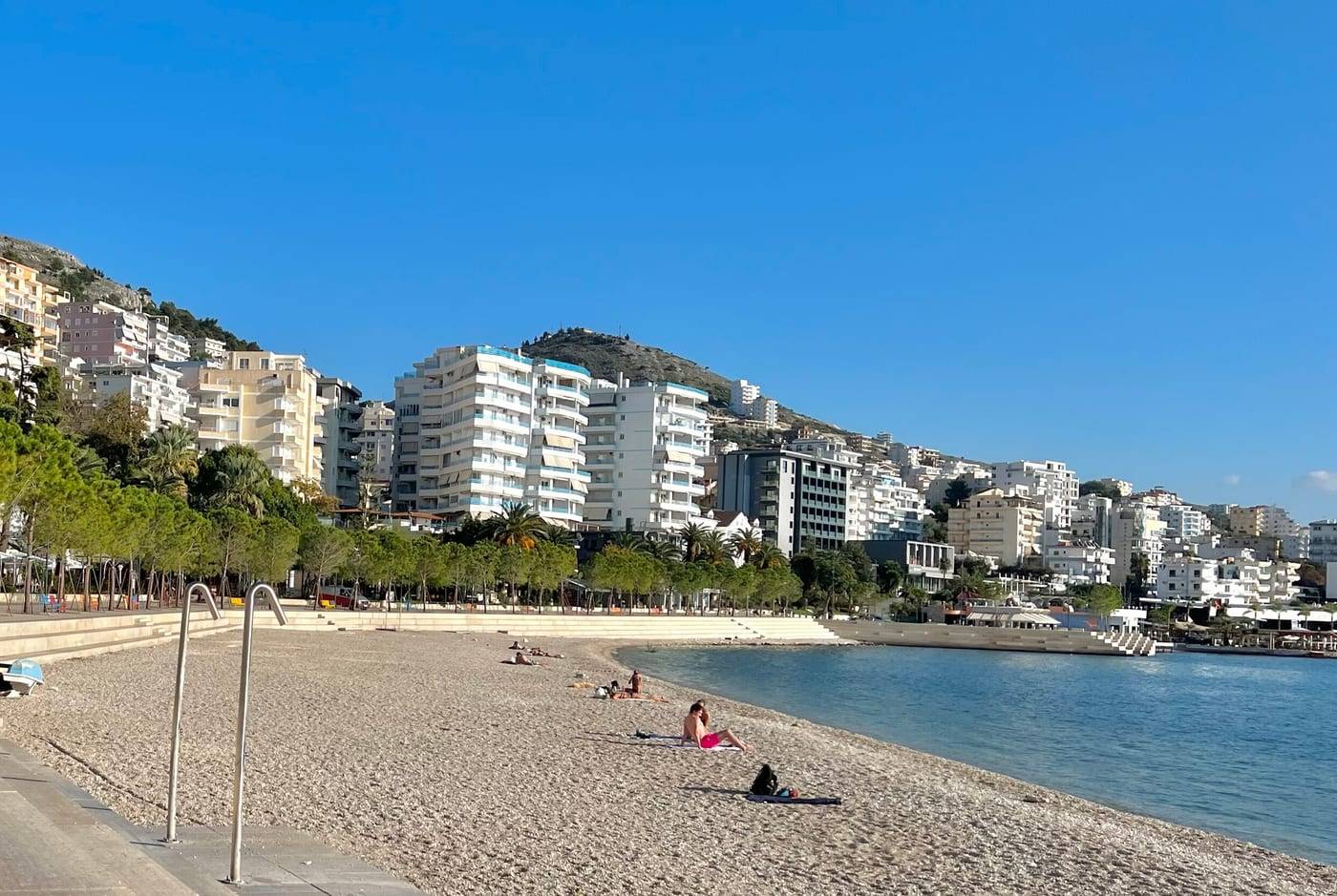 The wooden boardwalk and the town beach on Saranda's seafront, with hotels on the hillside behind