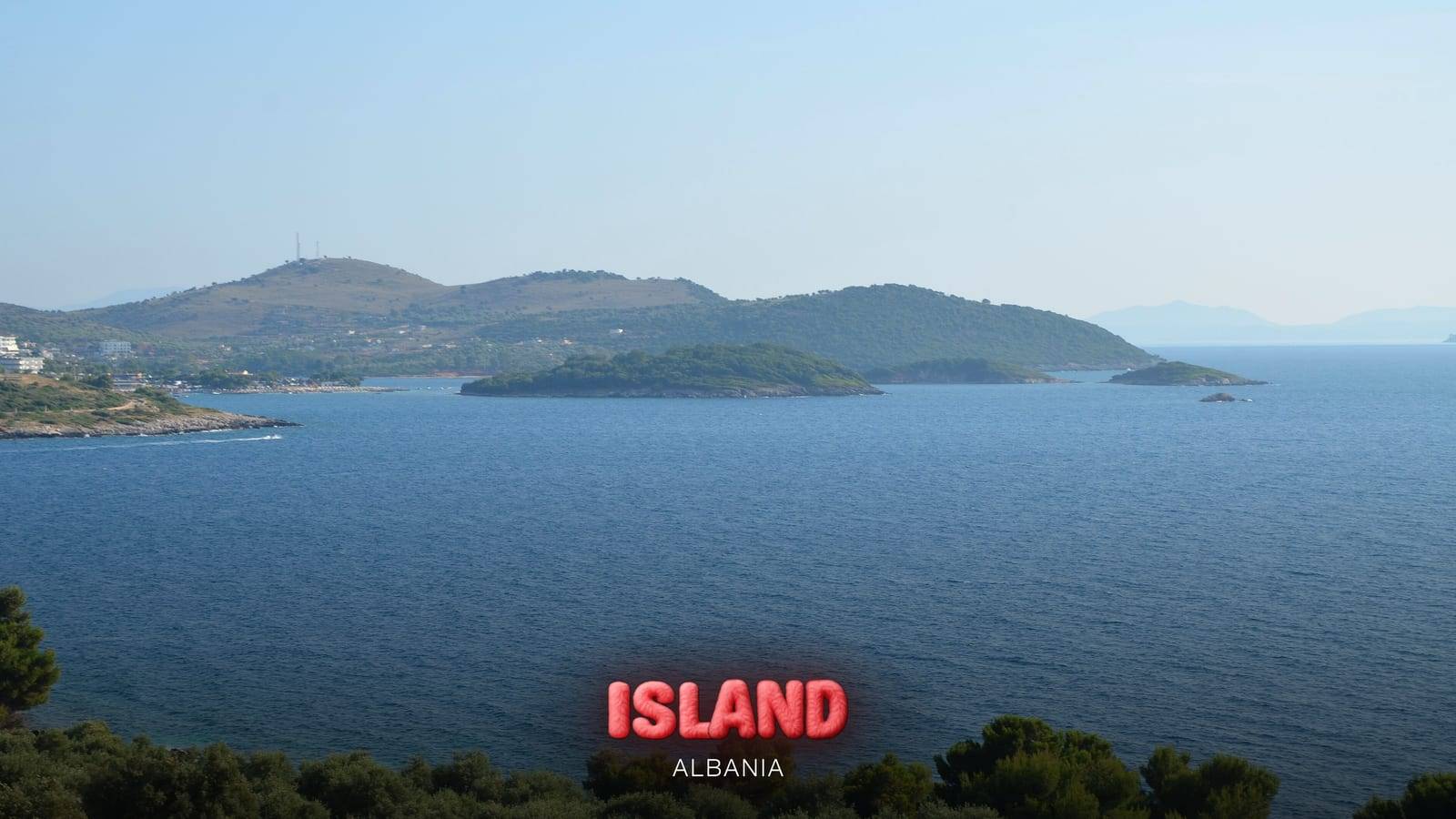 The islets off Ksamil and the Riviera coast seen from a hillside, with the Party Island Albania logo