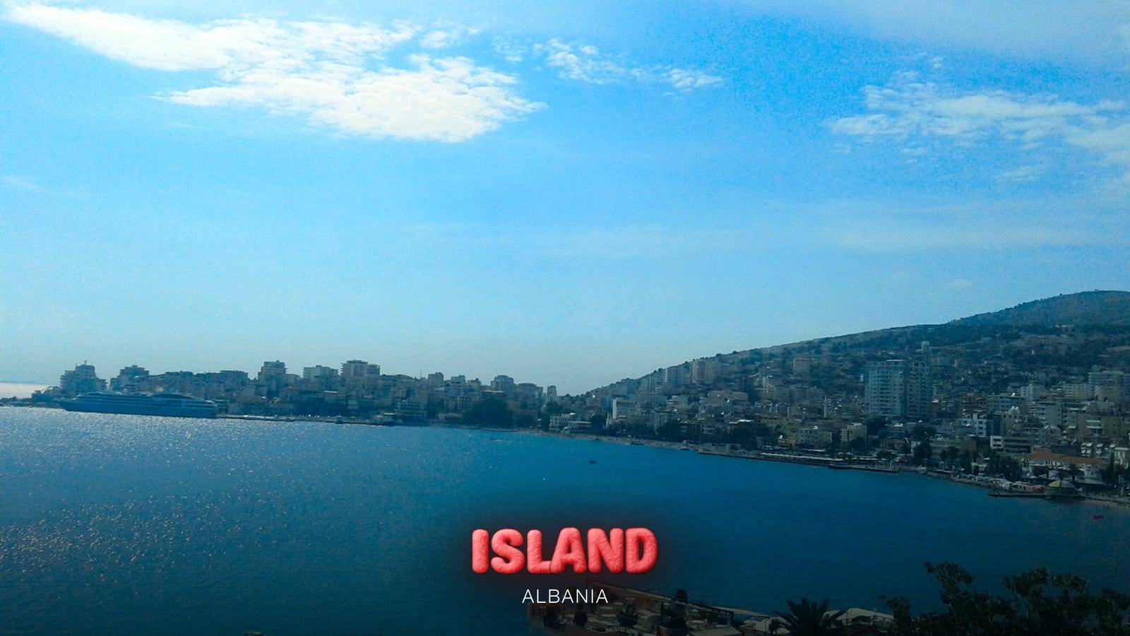 The bay of Saranda and the town along the waterfront, where boats from Corfu arrive, Albania, with the Party Island Albania logo