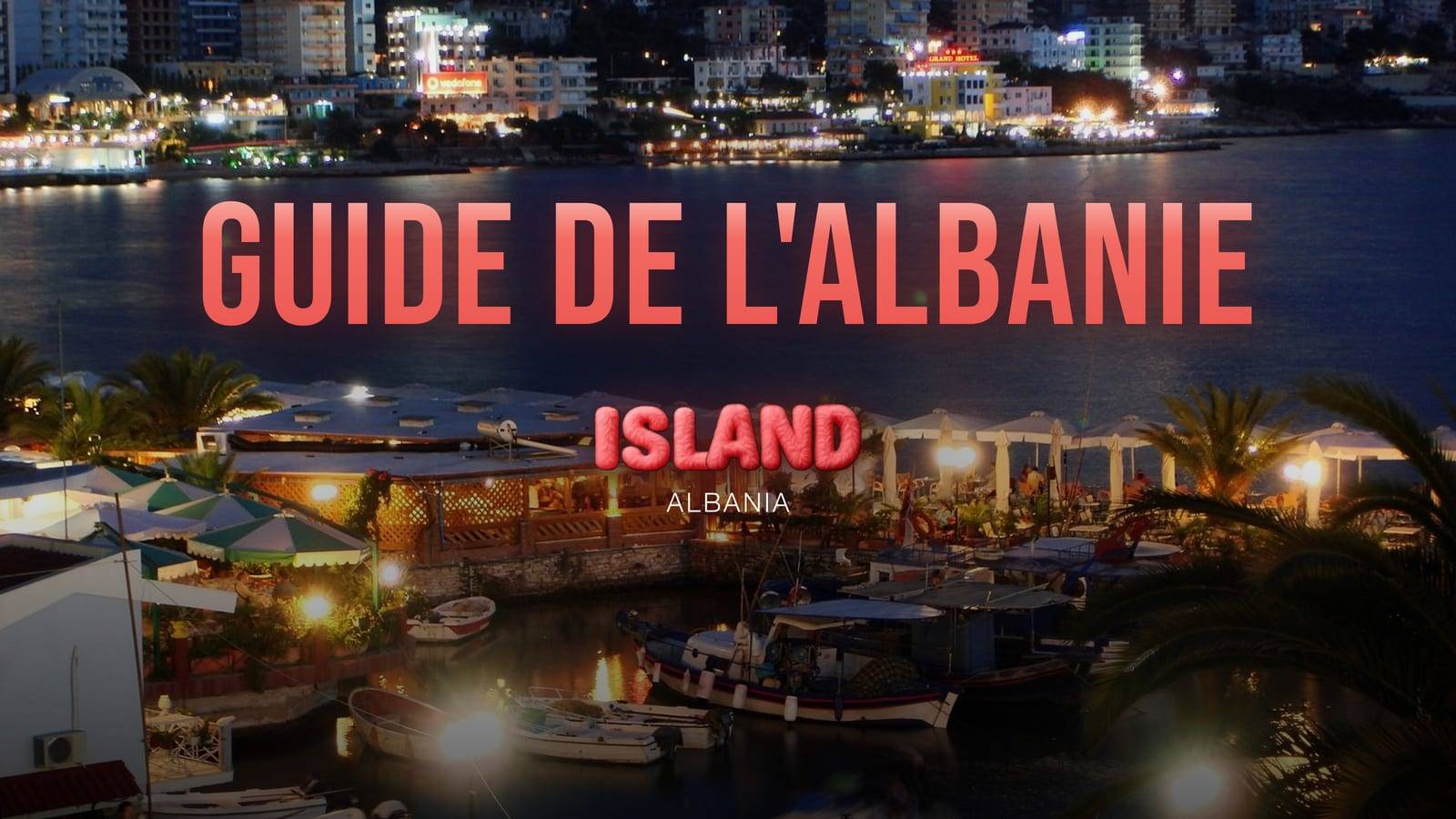 Saranda la nuit : le petit port avec ses bateaux et une terrasse éclairée, et les lumières de la ville de l'autre côté de la baie, avec le titre du guide et le logo de Party Island Albania